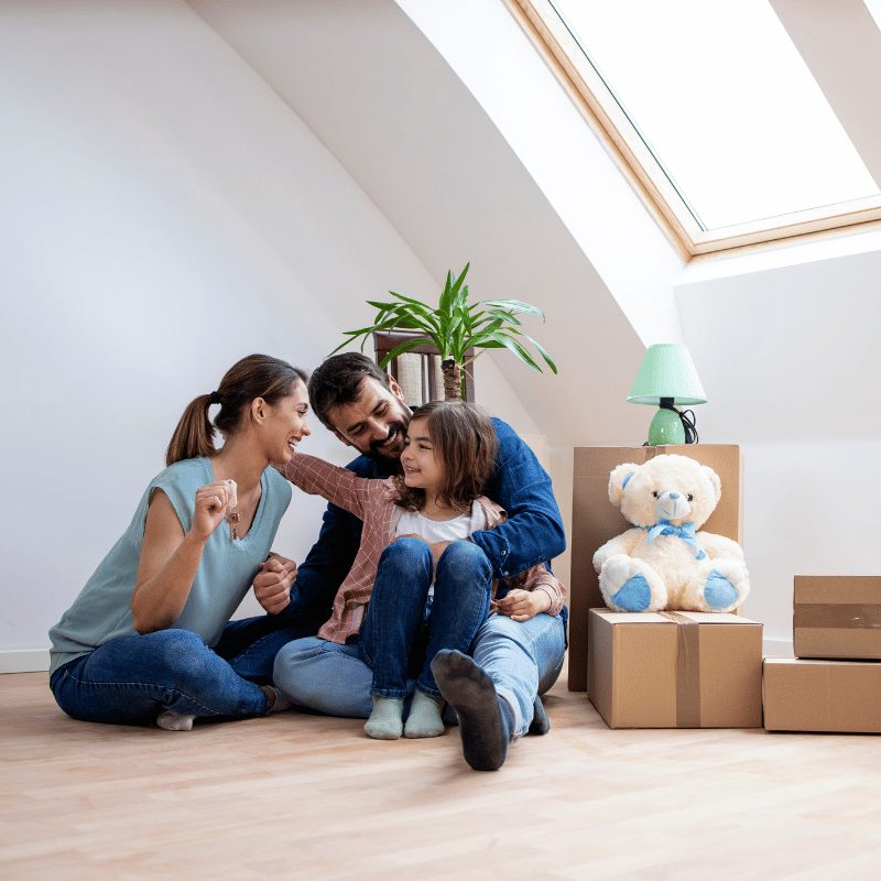 Familia disfrutando de su hogar con cajas de mudanza, simbolizando la seguridad y el bienestar que ofrece Seguros CCS